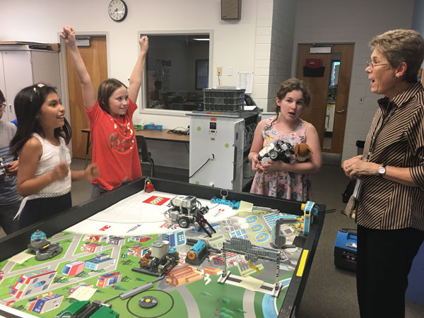 Three Robotics students with instructor