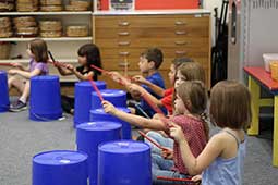 Kindergarten students drumming in classroom